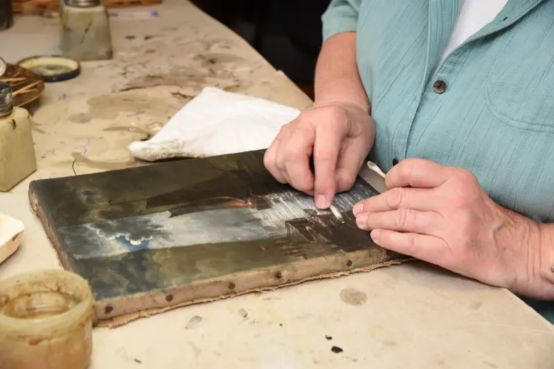 Restaurator bei der Reinigung eines Gemäldes im Atelier in Berlin